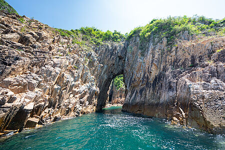 Exklusiver Ausflug in den Sai Kung UNESCO Geopark Die Vulkanlandschaft des Sai Kung Geoparks zeigt sich an Bord einer privaten Yacht von ihrer spektakulärsten Seite: Basaltsäulen, Höhlen und einsame Buchten wirken fast surreal. Ein Geologe begleitet auf Wunsch. Nach Badestopp oder Kajaktour folgt ein stilvoller Seafood-Lunch auf einem Ponton-Restaurant – fangfrisch, regional, mit Blick aufs stille Wasser. ©Hong Kong Tourism Board