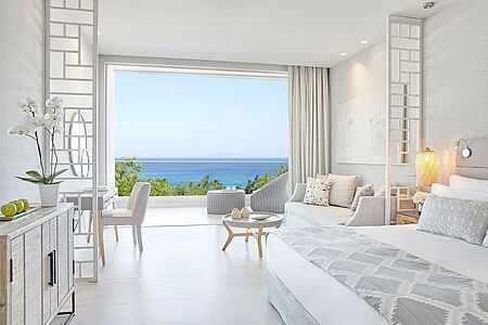 Junior Suite Diese ca, 40 qm großen, eleganten Suiten sind sehr geräumig, im modernen mediterranen Stil eingerichtet und bieten Platz für zwei Erwachsene und zwei Kinder. Die Panoramafenster und die voll möblierten Balkone bieten einen wunderbaren Blick auf das schillernde Ägäische Meer.