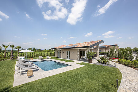 Garden Pool Villa 510 qm  Die hauseigenen Luxusvillen des Gardasee Quellenhof Luxury Resorts bieten noch mehr Privatsphäre und Luxus. Auf circa 510 qm – davon 110qm Wohnfläche und 400 qm Privatgarten erwarten Sie. Die beiden Schlafzimmer bieten Luxusbetten und ein eigenes Badezimmer mit Dusche & Bidet, Tages-WC, einen großzügigen Wohnraum mit lichtdurchflutetem Essbereich, Schlafcouch und eine offene Küche mit Kochinsel.