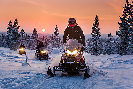 Snowmobile Safari searching for Northern Lights Diese private Schneemobil-Safari führt in die verschneiten Wälder, weg von der Stadt, um den Himmel zu bewundern. Genießen Sie am Lagerfeuer ein Picknick mit „Makkara“-Würstchen und lappländischem Beerennektar, während Sie auf die Nordlichter warten. Ein Stativ für bessere Fotos kann mitgebracht werden.