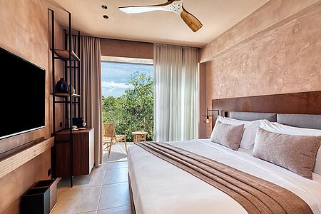 Tropical Retreat Diese komfortablen Zimmer sind mit einem bequemen Doppelbett ausgestattet und verfügen über einen Balkon mit Blick in den Garten.