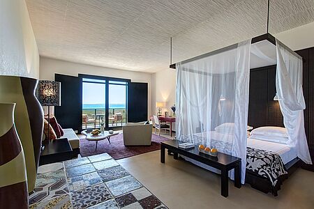 Junior Suite (ca. 60qm) Nehmen Sie Platz auf Ihrer privaten Terrasse und überblicken Sie die gigantischen Weiten des kristallblauen Meeres. Die Junior Suiten sind in hellen sowie leicht roten Farbtönen gehalten und bringen eine romantische Atmosphäre mit sich.