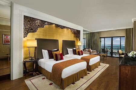 Grand Deluxe Familienzimmer (ca. 65 qm) Das über ein Kingsize-Bett sowie zwei Einzelbetten verfügende Grand Deluxe Familienzimmer bietet der gastierenden Familie neben wunderschönem Interieur in orientalischen Farben einen malerischen Meerblick. Das Badezimmer wartet mit türkischem Marmor auf und hat eine Badewanne und eine extra Dusche.