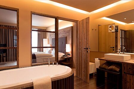 Suite (ca. 75 qm) Die Suiten des Hotels verfügen über ein separates Wohnzimmer mit Bio-Kamin und komfortablen Sitzgelegenheiten mit Schlafcouch. Die Badezimmer sind mit einer eigenen Infrarot-Sauna ausgestattet, die Toilette mit Bidet ist separat. Die Suiten verfügen außerdem über einen Südbalkon mit herrlichem Dolomiten-Blick.