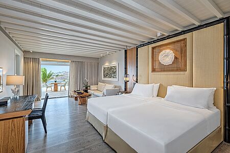 Sea View Suite Mit funkelnden Ausblicken auf die Ägäis ist diese Suiten offen konzipiert.
Der Wohnbereich umfasst ein bequemes Sofa und einen Lounge-Sessel. Der private Balkon oder die Terrasse ist mit Tisch, Stühlen und Liegestühlen ausgestattet. Hier finden bis zu drei Personen in einem Doppelbett oder zwei Einzelbetten, teilweise mit Schlafsofa, Platz. Badezimmer mit Dusche und/oder Badewanne. Bis zu 40 m².