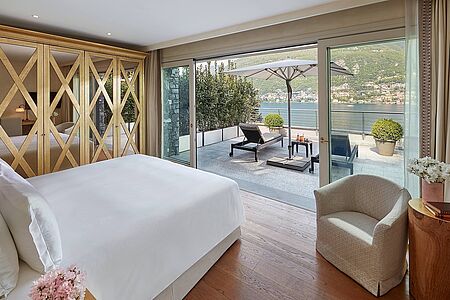 Vista Lago Terrace Room Diese geräumigen Zimmer verfügen über eine Außenterrasse mit schöner Aussicht auf den Comer See. Diese Zimmer können mit einer Suite verbunden werden. Modern im Design  genießen diese Zimmer einen Blick über den botanischen Park des Resorts. Jedes Zimmer verfügt über eine möblierte Außenterrasse mit Blick auf den Comer See.
