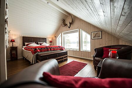 Master Cabin Inmitten der Wildnis finden Sie in der Master Cabin der Fjellborg Arctic Lodge ein warmes, einladendes Zuhause. Die zweistöckige private Lodge ist liebevoll im nordischen Stil gehalten.
Die Hütte ist eine Oase der wärmenden Ruhe mit umwerfendem Blick auf den See und verfügt über einen gemütlichen Holzofen im großen Wohnraum, drei gemütliche Schlafzimmer sowie eine Sauna.