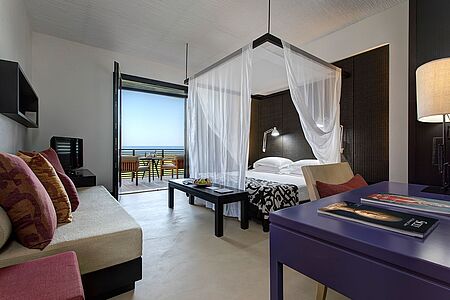 Deluxe Room (ca. 39-46qm) Das Deluxe Zimmer ist in hellen und leichten Lila-Tönen gestaltet und bringt Romantik und Komfort mit sich. Von Ihrer privaten Terrasse haben Sie einen bezaubernden Blick aufs Meer.