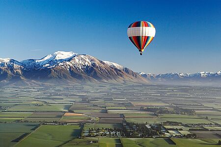 Ballonfahrt über Queenstown Für eine Heißluftballonfahrt müssen Sie zwar früh raus aus den Federn, aber bei diesen atemberaubenden Aussichten: Sie schweben über der gerade erwachenden Welt, erblicken Gipfel und Skiarenen wie Coronet Peak und The Remarkables von oben, entdecken Seen und Flüsse und den fast 3.000 Meter hohen Mount Earnslaw. Finale: ein prickelndes Champagnerfrühstück.