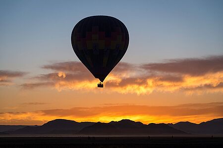 Ballonfahrt über der Namib Endlose Weiten, Wechselspiele zwischen Licht und Schatten, spektakuläre Farben und die eindrucks- volle Landschaft der Namib – eine Fahrt mit dem Heißluftballon bei Sonnenaufgang ist ein unvergessliches Erlebnis. Während Sie lautlos über die Dünen fahren, erwacht unter Ihnen die Wüste zum Leben. Nach der Landung wartet ein exklusives Champagner-Frühstück auf Sie.