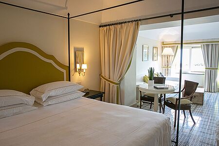 Deluxe Suite (ca. 40 qm) Die Suiten im Mezzatorre bieten Ihnen eine gemütliche Sitzecke und reichlich Wohnfläche. Die exklusiven Schlafräume und Wohnräume befinden sich entweder im Turm oder in den Cottages des Parks, mit typisch mediterraner Vegetation. Die Bucht San Montano ist von dieser Lage perfekt zu erkennen und verwöhnt Sie mit atemberaubenden Aussichten.