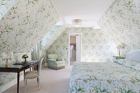 Saint Honoré Suite (ca. 110 qm) Die Besonderheit der Saint Honoré Suite liegt in ihren hohen Fenstern, die für perfekten Lichtfluss und angenehme Atmosphäre sorgen. Die Suite hat einen vom Wohnraum abgetrennten Umkleideraum und beinhaltet zudem zwei Badezimmer. Für optische Hingucker sorgen vielseitige Dekorationselemente.