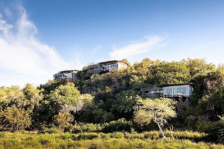 Singita Lebombo Lodge Im Osten des Krüger Nationalparks erwartet Sie die spektakuläre Singita Lebombo Lodge. Die vollverglasten Designerlofts verbinden futuristische Wohnkultur gekonnt mit einmaligem Safarierlebnis. Wie ein Adlernest schmiegen sich die Suiten an den Hang einer Basaltklippe und bieten fantastische Ausblicke auf eine der wildreichsten Regionen im Krügerpark.