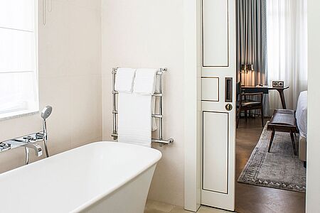 Grand Deluxe Rooms (ca. 35 qm) In diesen Luxuszimmern trifft elegantes Design auf angesagten zeitgenössischen Stil. Die Mid-Century-Opulenz, wie es The Norman bezeichnet, rundet die ohnehin schon sehr gelungene Optik ab. Besonderes Highlight: das edle Badezimmer samt tiefer Wanne, separater Regendusche und angenehm hellem Licht.