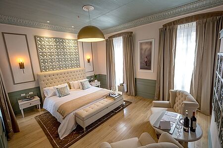 Republican Suite Junin (ca. 43 qm) Tauchen Sie ein in einen Traum aus Moderne und der Zeit der Republikaner. Genießen Sie eine Tasse heißer Schokolade in einem der gemütlichen Sessel in der großzügigen Suite. Entspannen Sie in der Badewanne und verwöhnen Sie ihre Haut mit L‘Occitane-Kosmetik-Produkten.