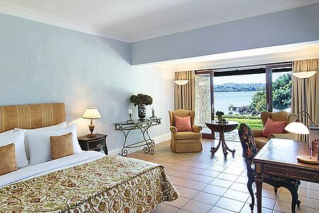 Junior Bungalow Suite Seaview 46 m² Diese Suite im korfiotischen Landhausstil liegt direkt an der Meeresfront mit direktem Strandzugang und ein wunderschöner Garten ist die ultimative Mischung aus zeitloser und gastfreundlicher Dekoration. Es erwarten Sie ein Doppelbett, ein Einzelbett, ein Badezimmer mit Badewanne und begehbarem Kleiderschrank und ein direkter Gartenzugang.