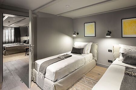 Familien Suite 45 qm Diese Suite verfügt über 2 Schlafzimmer und eine einladende Terrasse. Ein Kingsize-Bett und zwei Einzelbetten erwarten Sie. Im Badezimmer finden Sie eine begehbare Dusche sowie exklusive Pflegeprodukte. Der 24-Stunden-Zimmerservice und der Turn-Down-Service machen Ihren Aufenthalt perfekt.