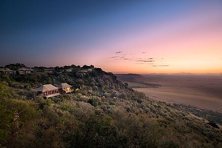 Auf der Hochebene des Rift Valley in Masai Mara liegt das Luxuscamp Angama Mara. 300 Meter hoch über der Savanne thronen 30 Zelt-Suiten, die an traditionelle Safari Zelte erinnern, aber große Glasfronten mit bodentiefen Panoramafenstern ermöglichen – egal, wo Sie sich in Ihrer Suite aufhalten - einen gigantischen Ausblick auf die Landschaft.
