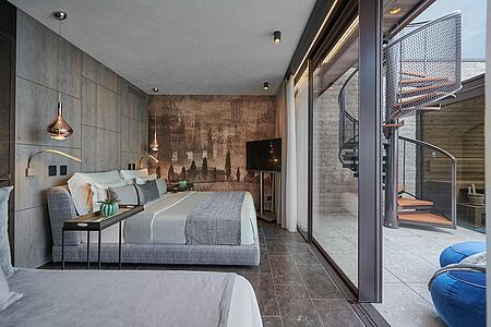 Penthouse Pool Villa 265m² inkl. 75m² Loggia vor der Suite, 58m² Dachterrasse und 4x8 m Infinitypool, für 2-5 Personen. Auf 2 Etagen,
1 Schlafzimmer mit Kingsize-Bett, 1 Schlafzimmer mit Kingsize-Bett und Einzelbett, begehbarer Kleiderschrank, Wohnzimmer mit Couch, 3 Flat-TV, 2 Bäder mit Rainshower & Bidet, Nespressomaschine & Teestation, Minibar, Holzboden, Blick auf den Garten, Whirlpool, private Sauna und Infinitypool