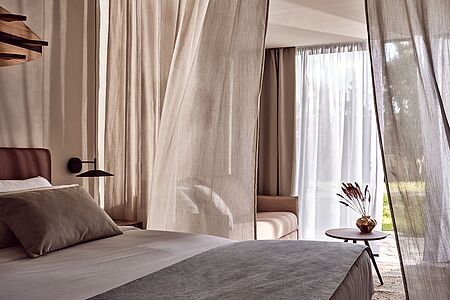 Das Schlafzimmer mit Doppelbett bietet ein Höchstmaß an Komfort und Privatsphäre mit Gartenblick. Erdige Farben treffen auf eine moderne Ästhetik, die jeden denkwürdigen Moment anmutig umarmt. Freuen Sie sich auf geräumige Innenräume mit unvergleichlichem Design und die Annehmlichkeiten von Cool Living. 