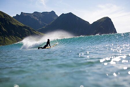 Bereiten Sie sich auf ein Arctic Surf-Erlebnis vor! In Unstad erhalten Sie alles, was für eine erfolgreiche Surfsession nötig ist – von passgenauen Neoprenanzügen bis hin zu praktischen Surf- und Sicherheitstipps am Strand. Im Wasser lernen Sie das Wellenreiten, vom Einstieg bis zum „Pop-up“ und dem Umgang mit einem Sturz. Nach einer tollen Session wartet die Sauna auf Sie.