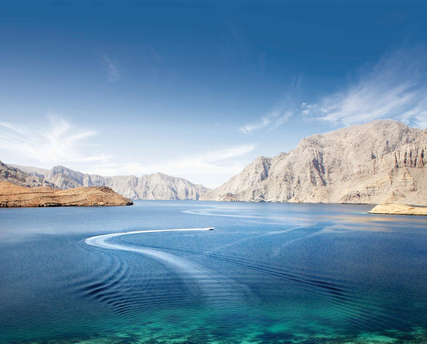 Spiegelglatt liegen die Gewässer von Musandam inmitten der imposanten Berglandschaft © @omanconvention-2